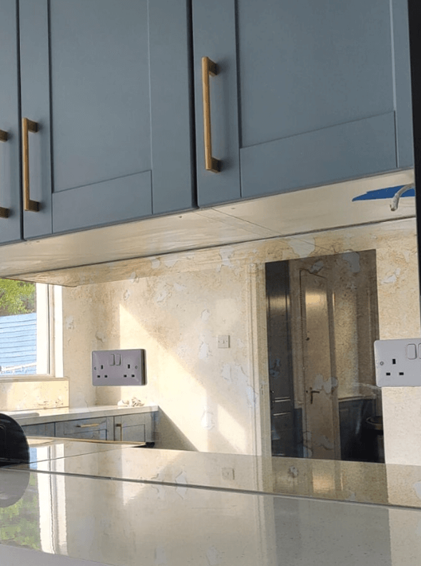 Antique Splashback Mirror Fitted In A Kitchen Kitchen With Blue Cabinets, Gold Handles, And Antique Mirror Splashback.