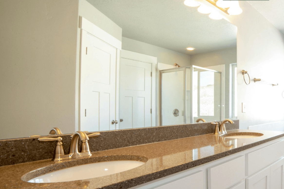 Double Sink Vanity With Brown Marble Countertop And Gold Faucets