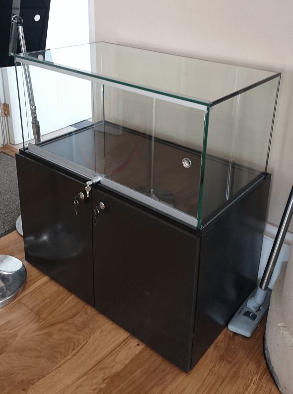 Black Cabinet With Glass Sliding Doors For Secure Display And Storage.