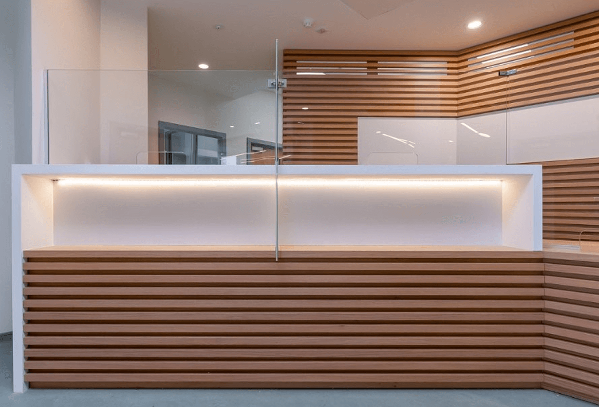 Glazed Transaction Glass Panels In A Reception Area Modern Reception Desk With Horizontal Wooden Slats And Glass Privacy Panel