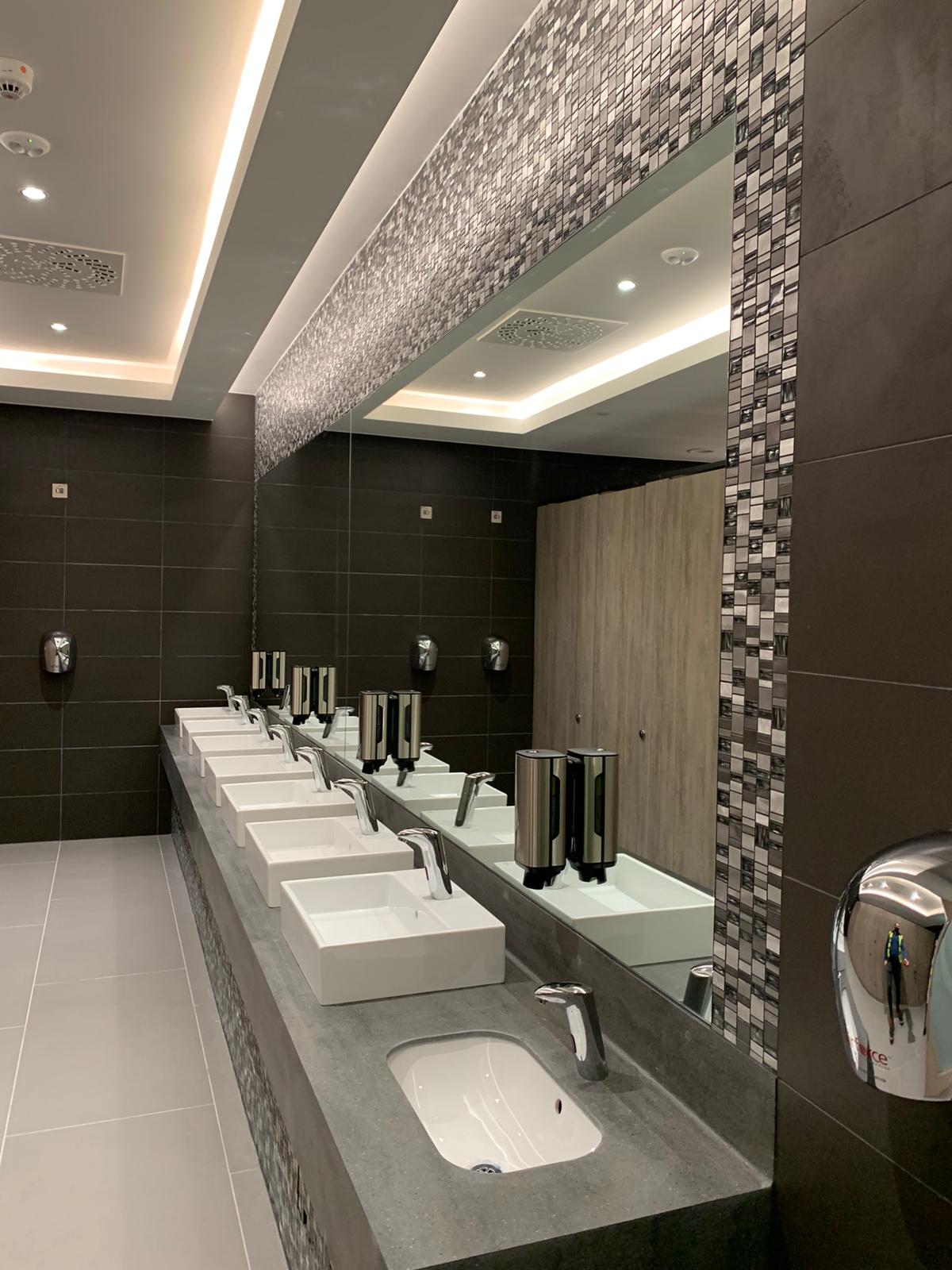 Modern Bathroom With Multiple Sinks, Mirrors, And Mosaic Tile Accents