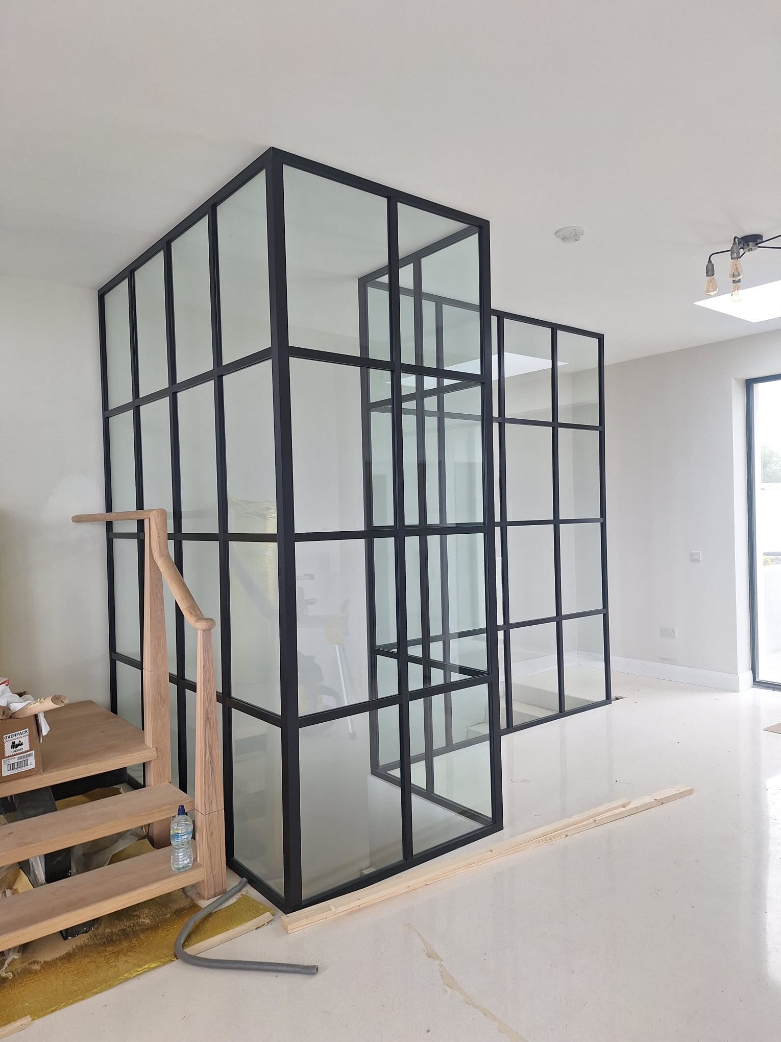 Crittal Style Partition Black-Framed Glass Partition With Grid Design In A Modern Interior Under Construction.